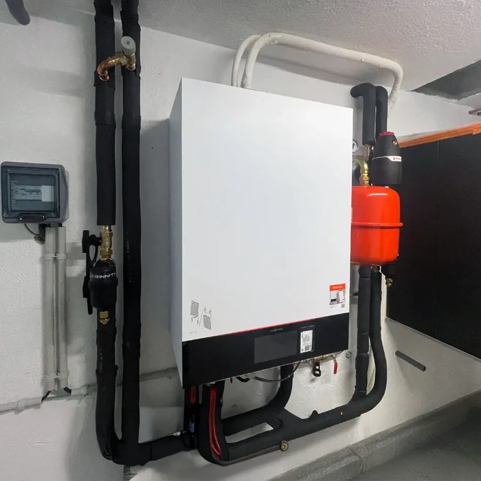 Intérieur d'une chaufferie moderne avec chaudière murale blanche installée