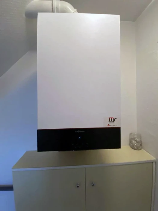 Intérieur résidentiel moderne avec chaudière murale blanche installée sur meuble de rangement blanc