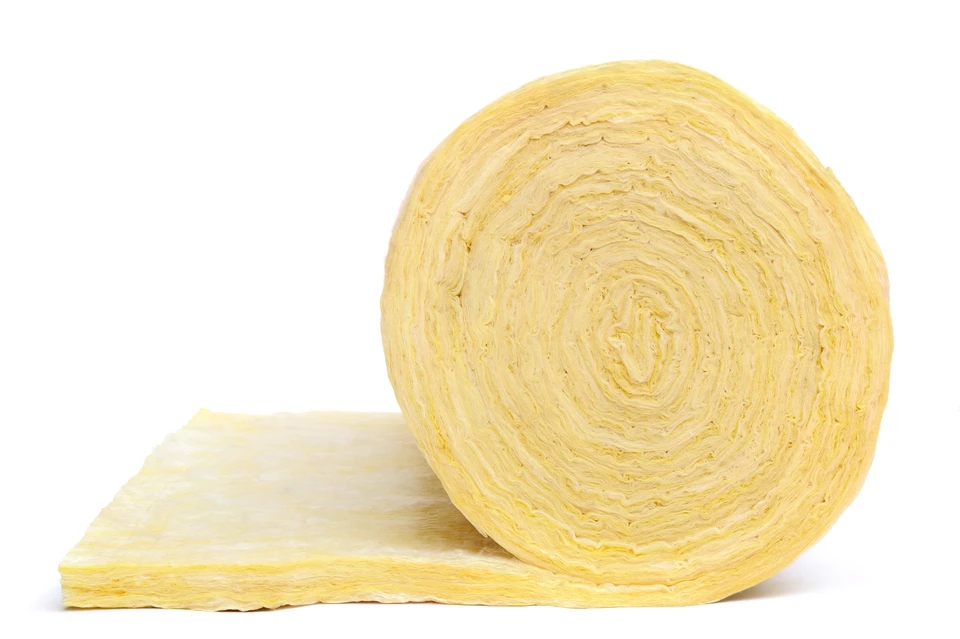 Scène en studio sur fond blanc neutre montrant un rouleau d'isolant thermique jaune partiellement déroulé, matériau posé à plat créant une composition épurée pour présentation commerciale