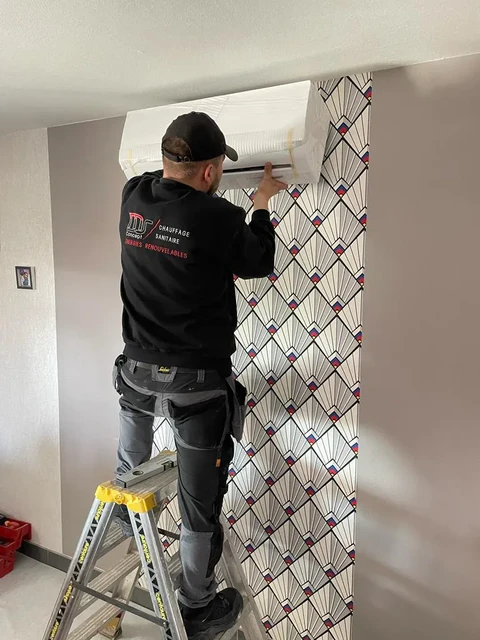 Technicien en chauffage installant une unité de climatisation murale dans un intérieur résidentiel