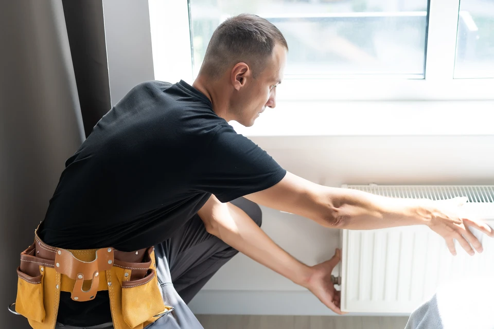 Technicien en chauffage travaillant sur une installation de chauffage central dans un local technique