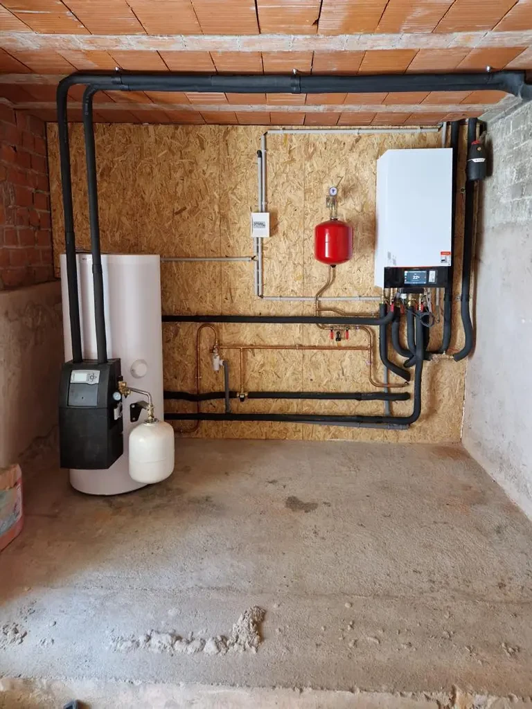 Ouvrier installant des panneaux photovoltaïques sur toiture plate, environnement résidentiel européen avec maisons traditionnelles